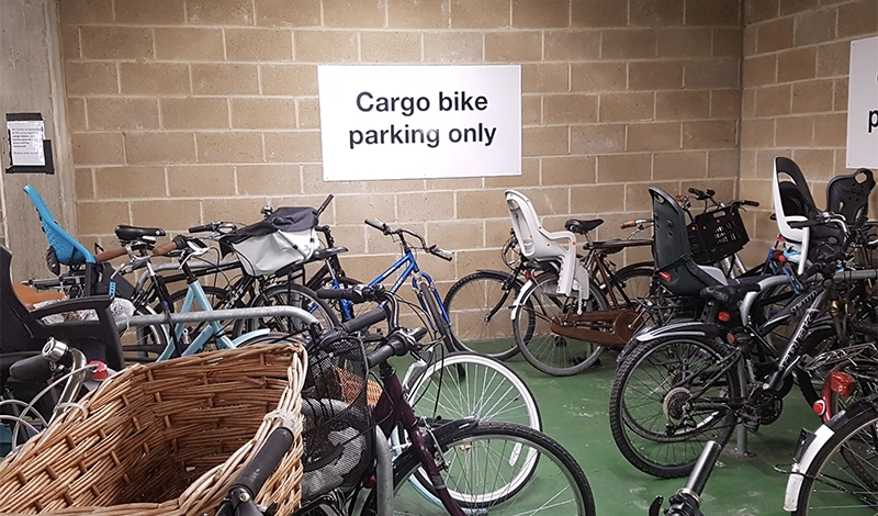 Many ordiary bikes parked in a cargo-bike only area