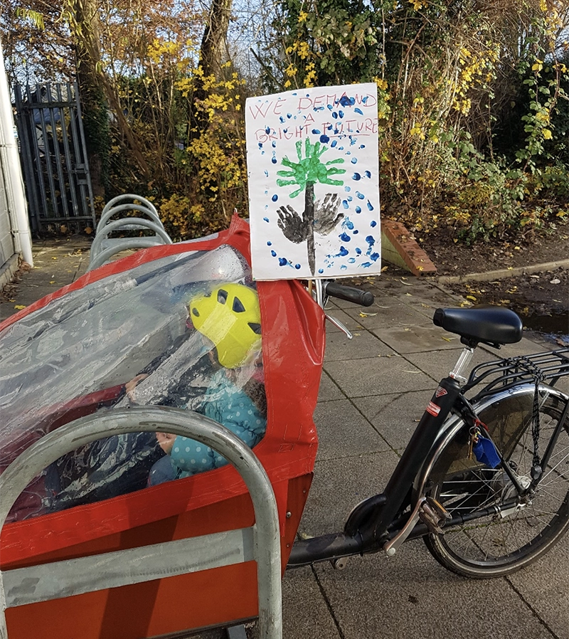 Cargo bike with child's finger painting of a tree and bright future in text