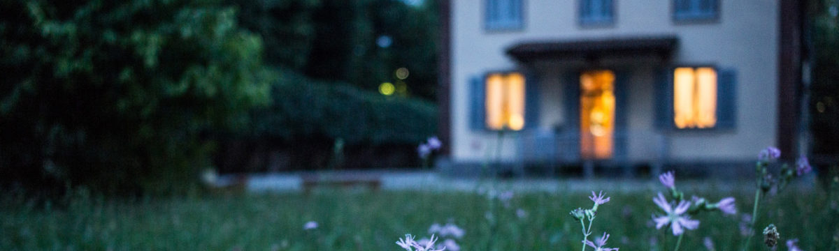 House at dusk with lights at the wondows. Photo by Valentina Locatelli on Unsplash